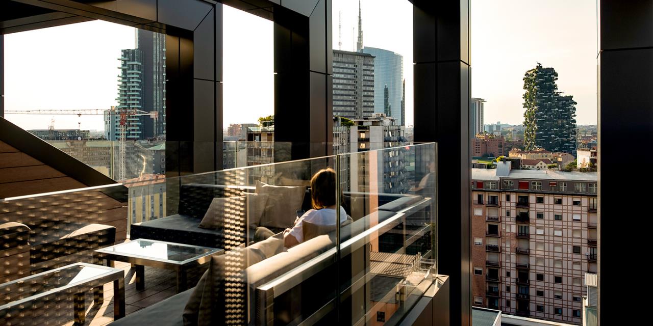Cliente assises salon terrasse devant un paysage urbain