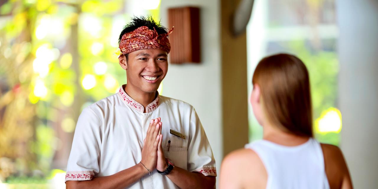 Yoga teacher in a hotel, saluting his student