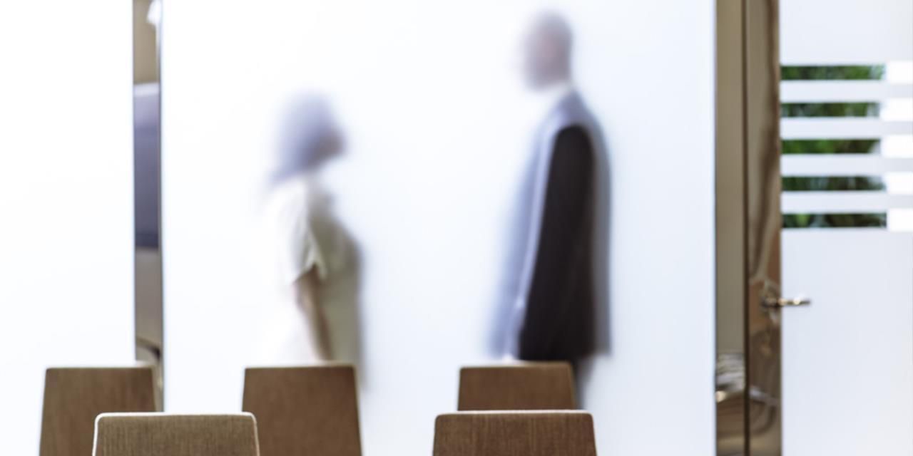 intérieur Salle de réunion lumineux femme et homme face a face derrière vitre verre dépoli